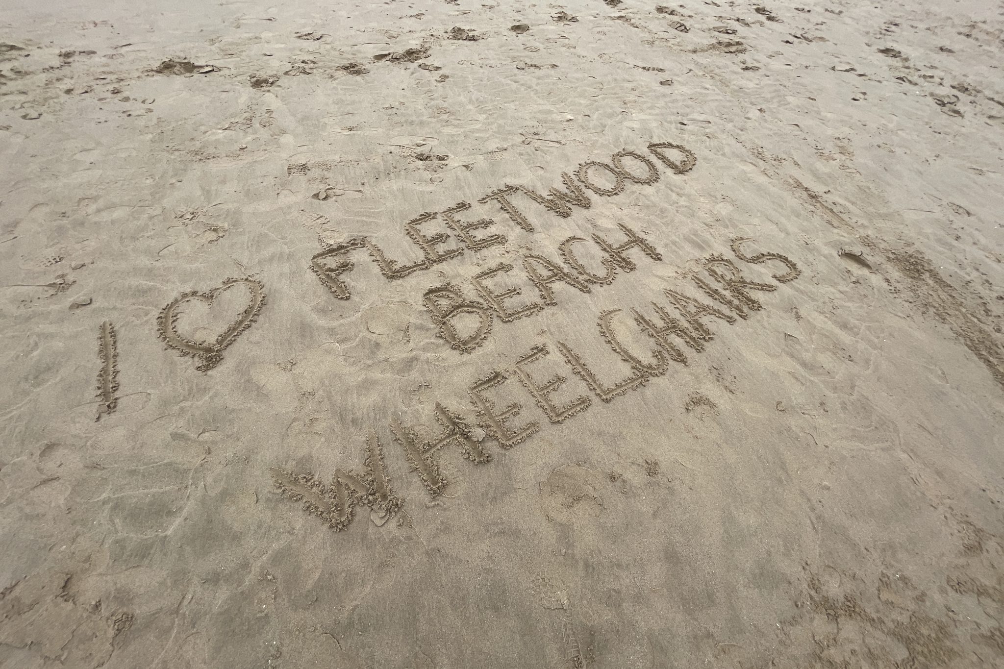 I love Fleetwood Beach Wheelchairs written with a heart in the sand